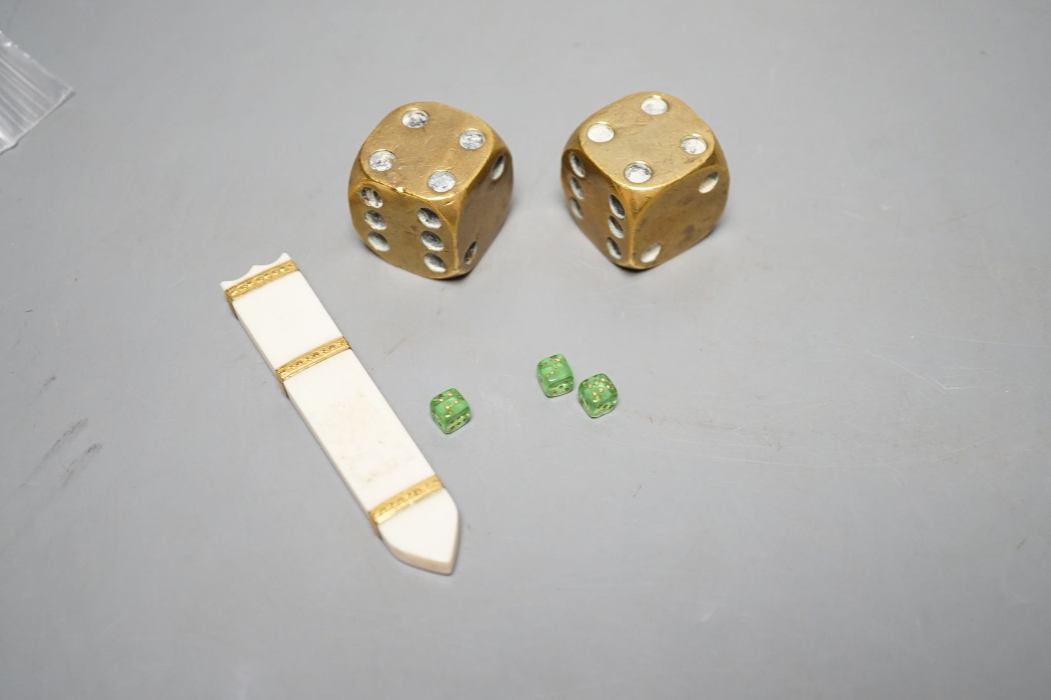 A late 18th century ivory and gold mounted needle case, two brass dice and three mini dice